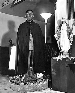 Rev. Gassaway standing in a bowl of sacred water.