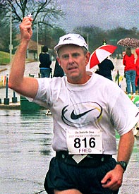 Fred Kondritz holds up Mom's Cross at the finish line.